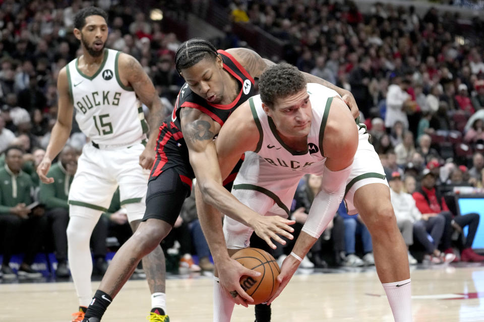 Milwaukee Bucks' Brook Lopez grabs a rebound as Chicago Bulls' Dalen Terry tries to strip the ball away from during the first half of an NBA basketball game, Thursday, Nov. 30, 2023, in Chicago. (AP Photo/Charles Rex Arbogast)