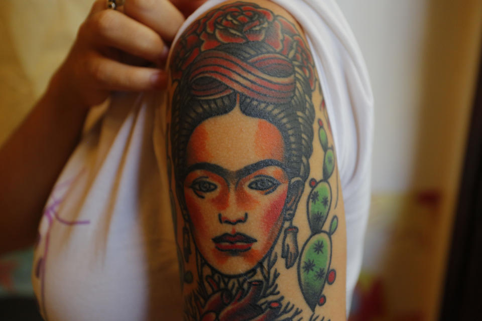 ARCHIVO - Dione Lugones muestra su tatuaje a semejanza de la artista mexicana Frida Kahlo, en su salón de tatuajes en La Habana, Cuba, el 3 de febrero de 2016. El 70 aniversario de la muerte de Kahlo es el 13 de julio de 2024. (AP Foto/Desmond Boylan, Archivo)