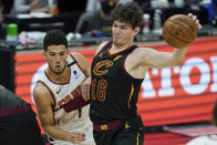 Cleveland Cavaliers' Cedi Osman, right, his fouled by Phoenix Suns' Devin Booker in overtime of an NBA basketball game, Tuesday, May 4, 2021, in Cleveland. Phoenix won 134-118 in overtime. (AP Photo/Tony Dejak)