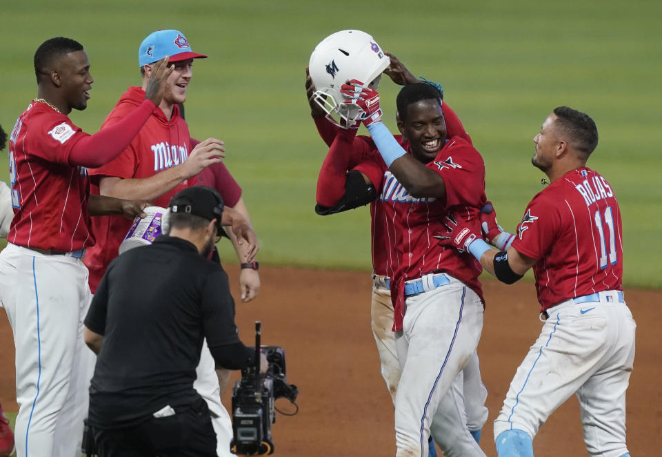 Miami Marlins players celebrate Jesus Sanchez, second from right, after he hit a sacrifice fly that scored the winning run during the ninth inning of a baseball game, Saturday, June 4, 2022, in Miami. The Marlins defeated the Giants 5-4. (AP Photo/Marta Lavandier)