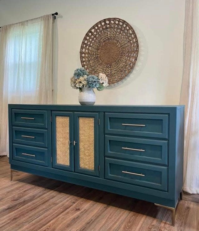 In upgrading and updating vintage furniture, Kelly Vankerhove of KJ Interiors/Furniture uses a lot of saturated colors, as in the case of this console cabinet painted deep teal blue. Other additions include new hardware and natural cane webbing on the doors.