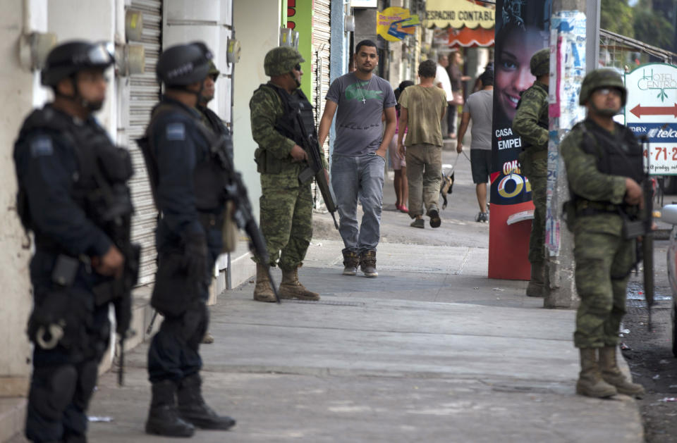 Policías y soldados federales montan guardia en Apatzingán, México, el miércoles 15 de enero de 2014. (AP Foto/Eduardo Verdugo)
