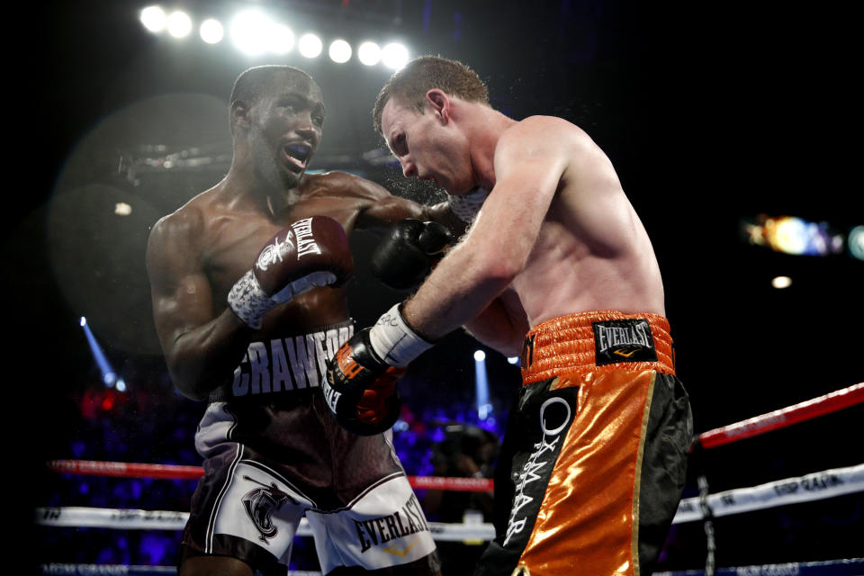 Terence Crawford (L) lands a punch on Jeff Horn in a welterweight title boxing match, Saturday, June 9, 2018, in Las Vegas. (AP Photo/John Locher)