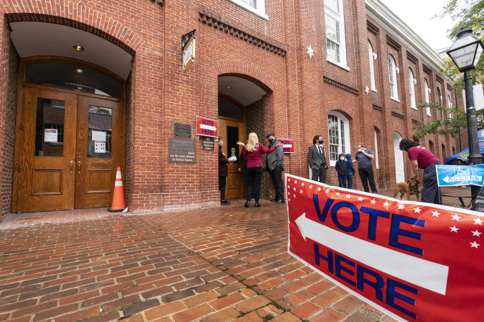 Voters arrive to cast the their ballots on Election Day at City Hall, Tuesday, Nov. 2, 2021 in Alexandria, Va. Voters are deciding between Democrat Terry McAuliffe and Republican Glenn Youngkin for governor. (AP Photo/Alex Brandon)