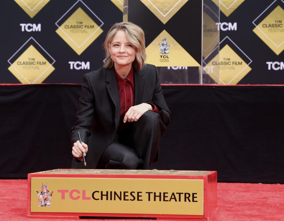 Jodie Foster signs her autograph in cement during the Handprint and Footprint Ceremony