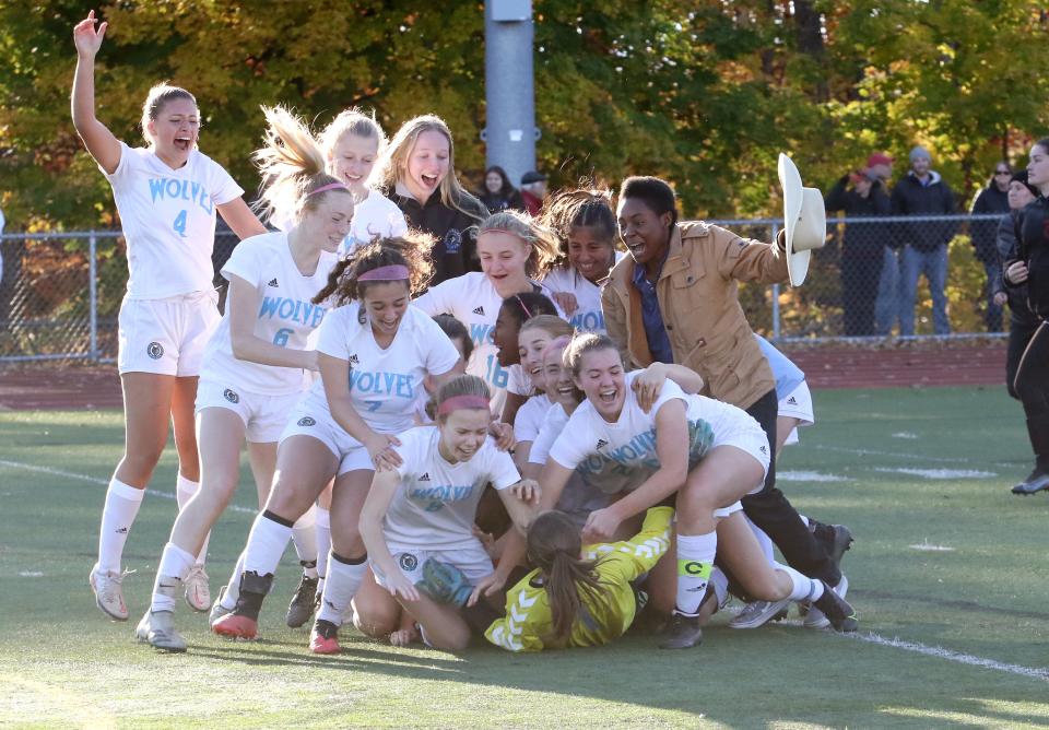Members of the South Burlington Wolves mob goalie Mercedes Rozzi after defeating CVU in the 2021 D1 State Championship game at Buck Hard Field.
