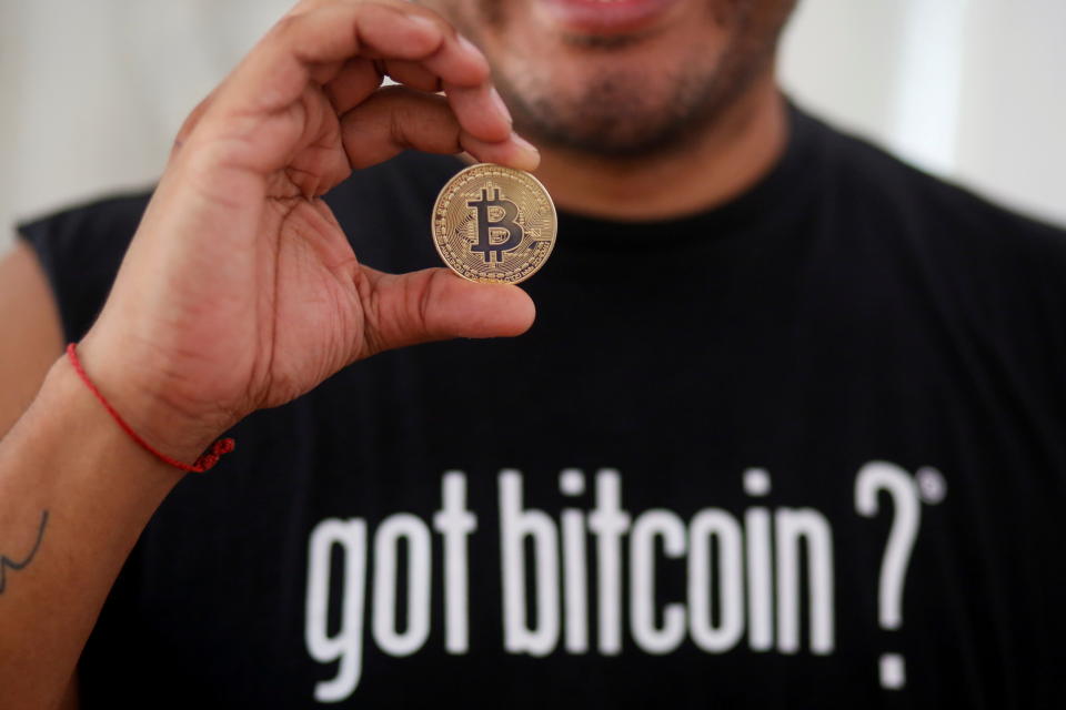 Bitcoin enthusiast Carlos Bonilla shows a physical representation of the cryptocurrency, at a Bitcoin Beach support office at El Zonte Beach in Chiltiupan, El Salvador June 10, 2021. Picture taken June 10, 2021. REUTERS/Jose Cabezas REFILE - CORRECTING INFORMATION