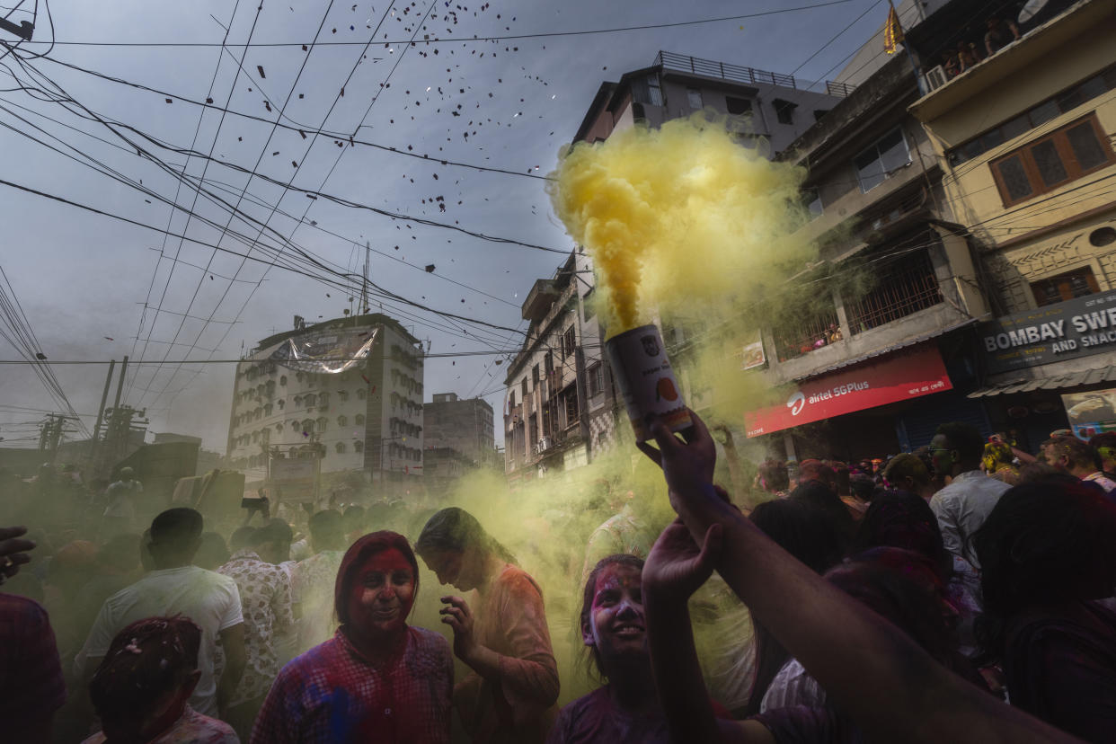 People celebrate Holi, the festival of colors on a street in Guwahati, India, Wednesday, March 8, 2023.Millions of Indians on Wednesday celebrated the ''Holi" festival, dancing to the beat of drums and smearing each other with green, yellow and red colors and exchanging sweets in homes, parks and streets. Free from mask and other COVID-19 restrictions after two years, they also drenched each other with colored water. (AP Photo/Anupam Nath)