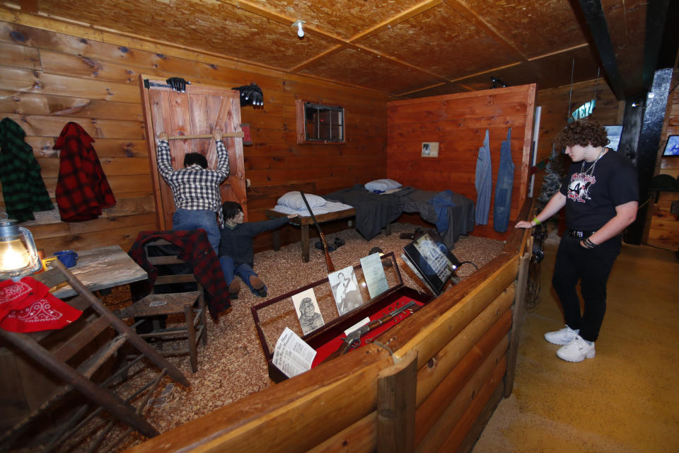 In this Aug. 8, 2019, photo, Jared Schultz looks at a display of a Bigfoot attack at Expedition: Bigfoot! The Sasquatch Museum in Cherry Log, Ga. The owner of this intriguing piece of Americana at the southern edge of the Appalachians is David Bakara, a longtime member of the Bigfoot Field Researchers Organization who served in the Navy, drove long-haul trucks and tended bar before opening the museum in early 2016 with his wife, Malinda. (AP Photo/John Bazemore)