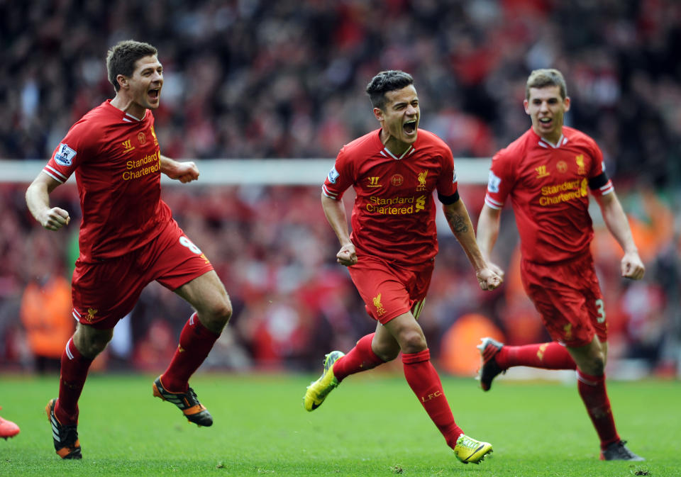 Liverpool's Philippe Coutinho centre, celebrates with team-mates Jon Flanagan right, and Steven Gerrard left, after he scores the third goal of the game for his side during their English Premier League soccer match against Manchester City at Anfield in Liverpool, England, Sunday April. 13, 2014. (AP Photo/Clint Hughes)