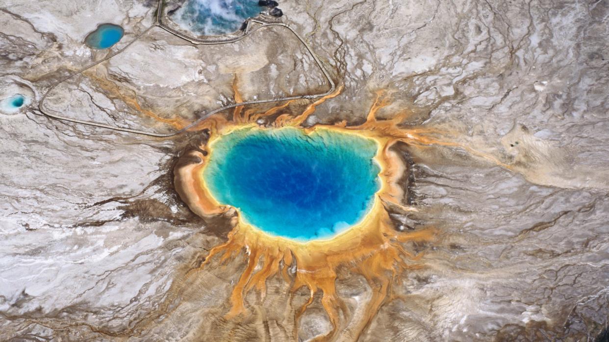  Aerial view of the Grand Prismatic Spring at Yellowstone National Park, with blue center and orange and yellow at the edges 