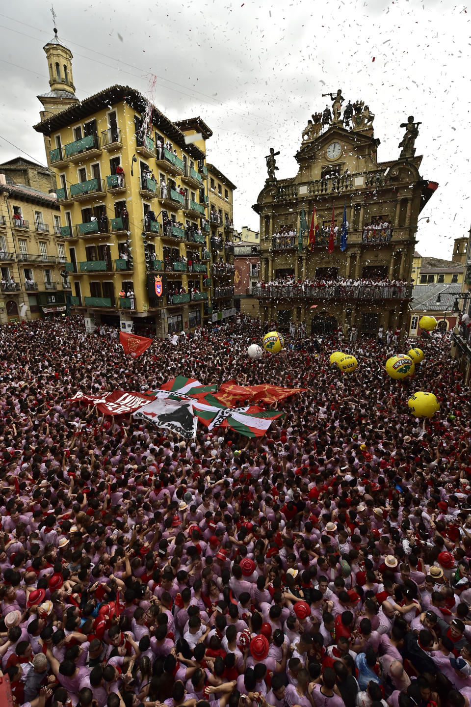 Revelers react during the launch of the 'Chupinazo' rocket, to mark the official opening of the 2022 San Fermin fiestas in Pamplona, Spain, Wednesday, July 6, 2022. The blast of a traditional firework opened Wednesday nine days of uninterrupted partying in Pamplona's famed running-of-the-bulls festival which was suspended for the past two years because of the coronavirus pandemic. (AP Photo/Alvaro Barrientos)