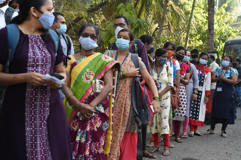 Frontline health workers queue to receive a dose of a Covid-19 coronavirus vaccine at the Cooper hospital in Mumbai on January 16, 2021. (Photo by Punit PARANJPE / AFP) (Photo by PUNIT PARANJPE/AFP via Getty Images)