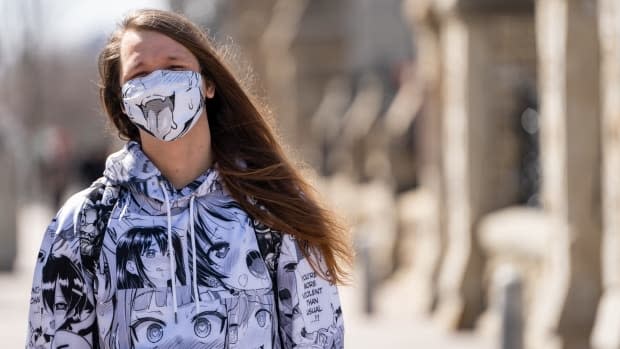 A man in a matching manga-themed mask and outfit stands on Wellington Street in Ottawa April 1, 2021. He told CBC it cost about $100 online.