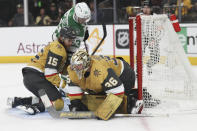 Vegas Golden Knights defenseman Noah Hanifin (15) collides into Dallas Stars center Wyatt Johnston (53) while Vegas Golden Knights goaltender Logan Thompson (36) makes a save during the third period in Game 3 of an NHL hockey Stanley Cup first-round playoff series Saturday, April 27, 2024, in Las Vegas. (AP Photo/Ian Maule)