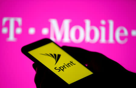 A smartphone with Sprint logo are seen in front of a screen projection of T-mobile logo, in this picture illustration taken April 30, 2018. REUTERS/Dado Ruvic/Illustration