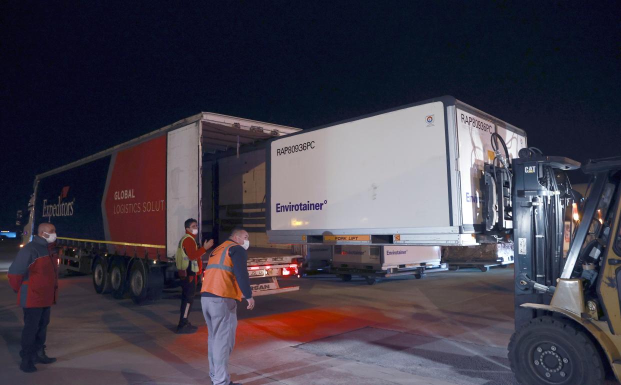 In this photo provided by the Turkish Health Ministry, officials unload the first batch of COVID-19 vaccine, CoronaVac, a so-called inactivated vaccine developed by Chinese biopharmaceutical company Sinovac Biotech, at Esenboga Airport in Ankara, Turkey, early Wednesday, Dec. 30, 2020. Turkey has signed a deal for 50 million doses of the vaccine with Sinovac Biotech.