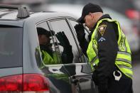 NEWTOWN, CT - DECEMBER 18: Police check a car arrving for the funeral of shooting victim James Mattioli, 6, at the St. Rose of Lima Catholic church on December 18, 2012 in Newtown, Connecticut. Funeral services were held at the church for both James Mattioli and Jessica Rekos, 6, Tuesday, four days after 20 children and six adults were killed at Sandy Hook Elementary School. (Photo by John Moore/Getty Images)