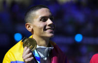 Gold medalist David Popovici of Romania poses with his medal after the Men 100m Freestyle final at the 19th FINA World Championships in Budapest, Hungary, Wednesday, June 22, 2022. (AP Photo/Petr David Josek)