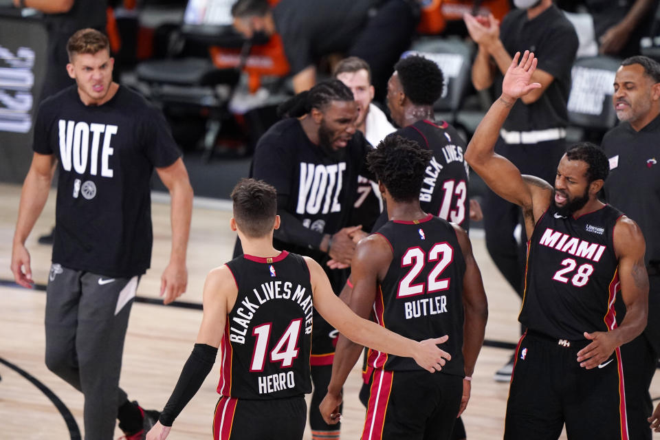 Miami Heat's Tyler Herro (14) and Miami Heat's Andre Iguodala (28) celebrate during the second half of an NBA conference final playoff basketball game against the Boston Celtics Sunday, Sept. 27, 2020, in Lake Buena Vista, Fla. (AP Photo/Mark J. Terrill)