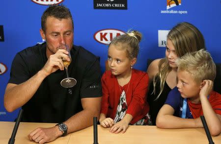 Australia's Lleyton Hewitt drinks champagne during a news conference while his children, Ava (2nd L-R), Mia and Cruz, watch after playing his last Australian Open singles match before his retirement, at the Australian Open tennis tournament at Melbourne Park, Australia, January 21, 2016. REUTERS/Issei Kato