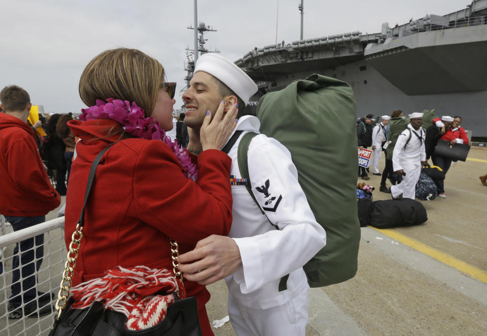 Kimberly Kline gives a kiss to boyfriend, Aviation Boson Mate Daniel Mechlin, of Chesapeake, Va., as he disembarked the nuclear aircraft carrier Harry S. Truman at Naval Station Norfolk in Norfolk, Va., Friday, April 18, 2014. The Truman Strike Group is returning from a 9-month deployment to the Middle East. (AP Photo/Steve Helber)