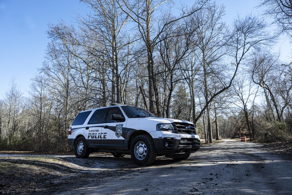 New Jersey State Park Police blocks Quaker Bridge in Washington Township, N.J., on Wednesday, Dec. 20, 2023. The location is near where a pilot and photographer were killed when Chopper 6 crashed in a wooded area in Washington Township in Burlington County on Tuesday evening. The helicopter was last spotted over Wharton State Forest. (Jose F. Moreno/The Philadelphia Inquirer via AP)