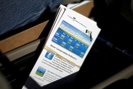 Leaflets explaining new water rules are seen in the car of Enrique Silva, Department of Water and Power (DWP) Water Conservation Response Unit supervisor, as he patrols the streets looking for people wasting water during the drought in Los Angeles, California, April 17, 2015. REUTERS/Lucy Nicholson