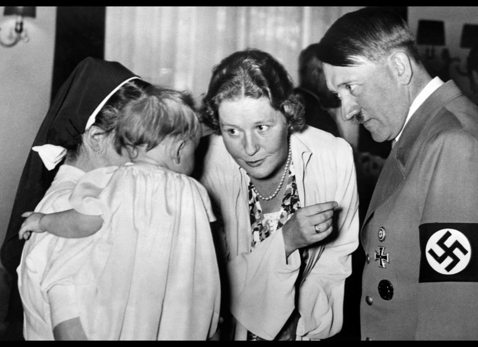 <p>A picture dated 1939 shows German Nazi Chancellor and dictator Adolf Hitler with his companion Eva Braun talking to a baby held by a nun. AFP/Getty Images</p>