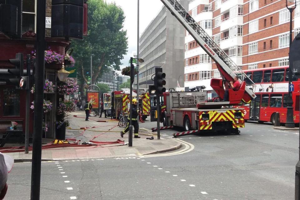 Crews using breathing an aerial ladder to reach the fire