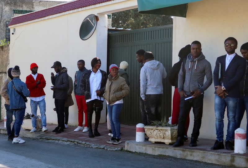 FILE PHOTO: Ivory Coast nationals living in Tunisia wait outside the embassy of Ivory Coast in Tunis