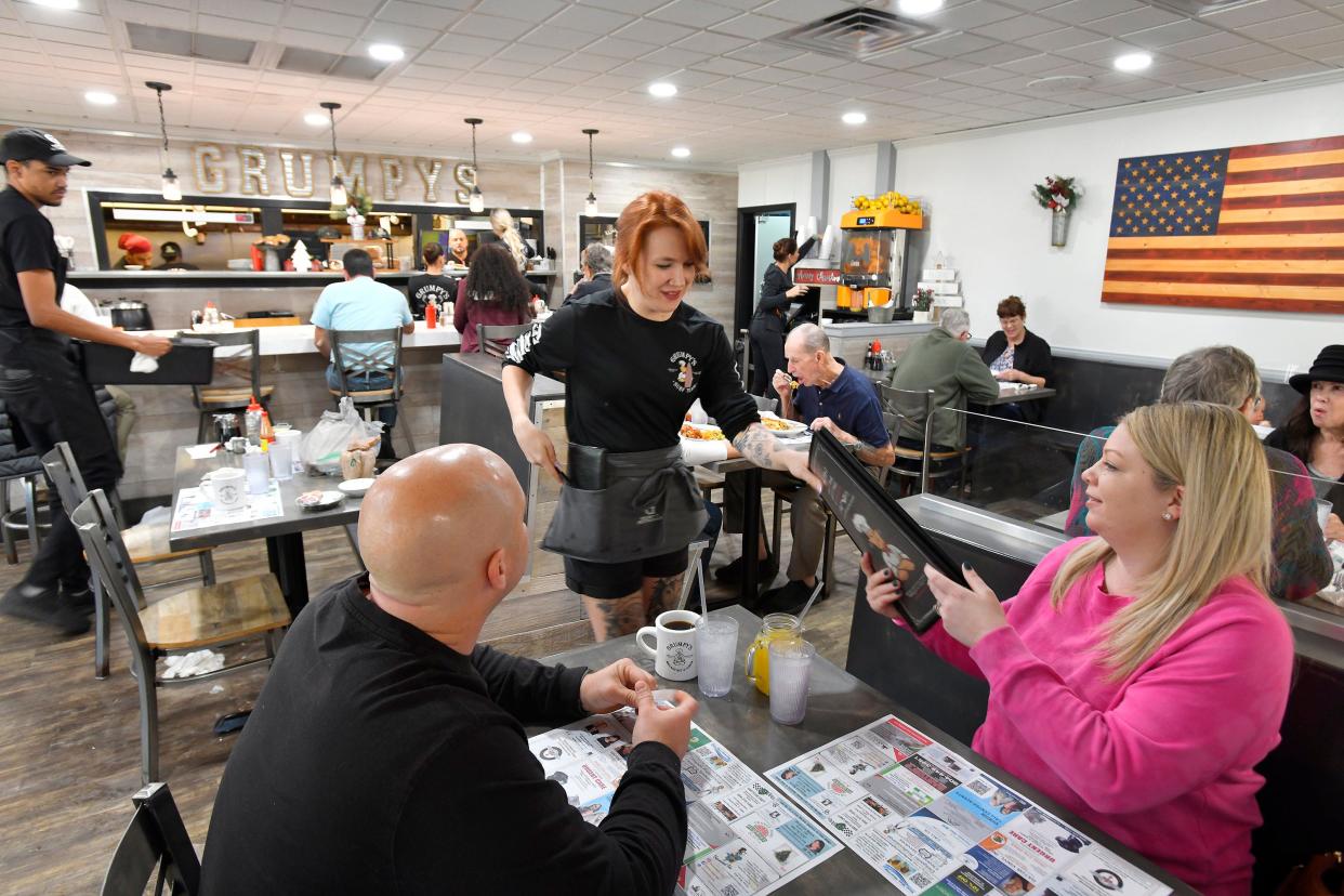 Waitress Mary Brown serves customers in the dining room of Grumpy's Restaurant in Orange Park earlier this month.