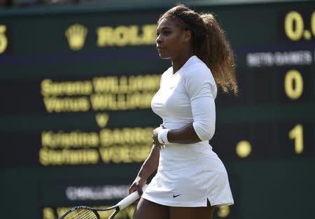 Serena Williams of the U.S. holds her stomach before retiring from her women's doubles tennis match with Venus Williams of the U.S. against Kristina Barrois of Germany and Stefanie Voegele of Switzerland at the Wimbledon Tennis Championships, in London July 1, 2014. REUTERS/Toby Melville