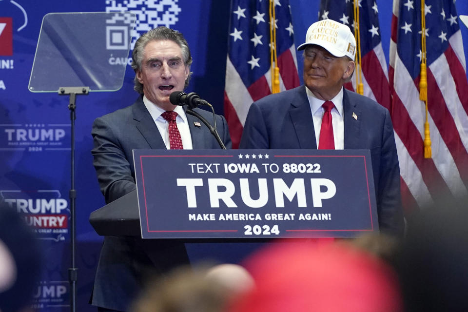 Republican presidential candidate former President Donald Trump listens as North Dakota Gov. Doug Burgum speaks at a rally at Simpson College in Indianola, Iowa, Sunday, Jan. 14, 2024. (AP Photo/Andrew Harnik)