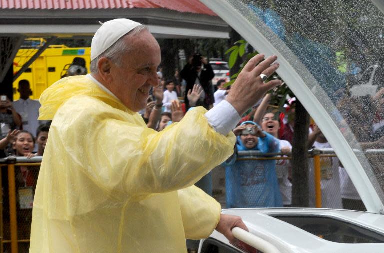 Pope Francis waves as he leaves following his visit to the University of Santo Tomas in Manila