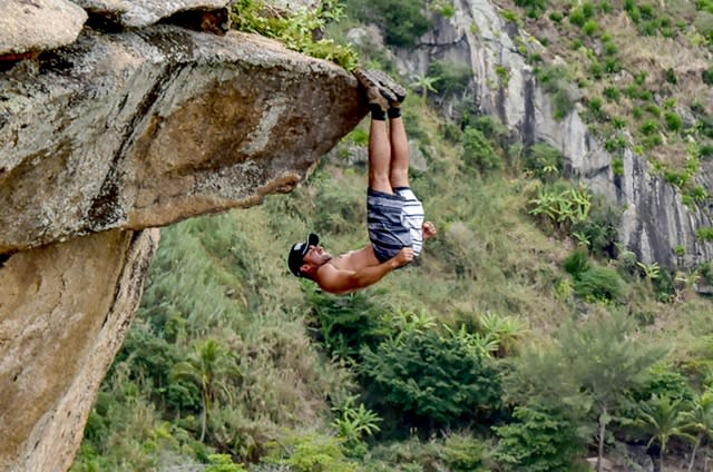 Cliffhanger! Upside-down daredevil uses feet to cling to cliff