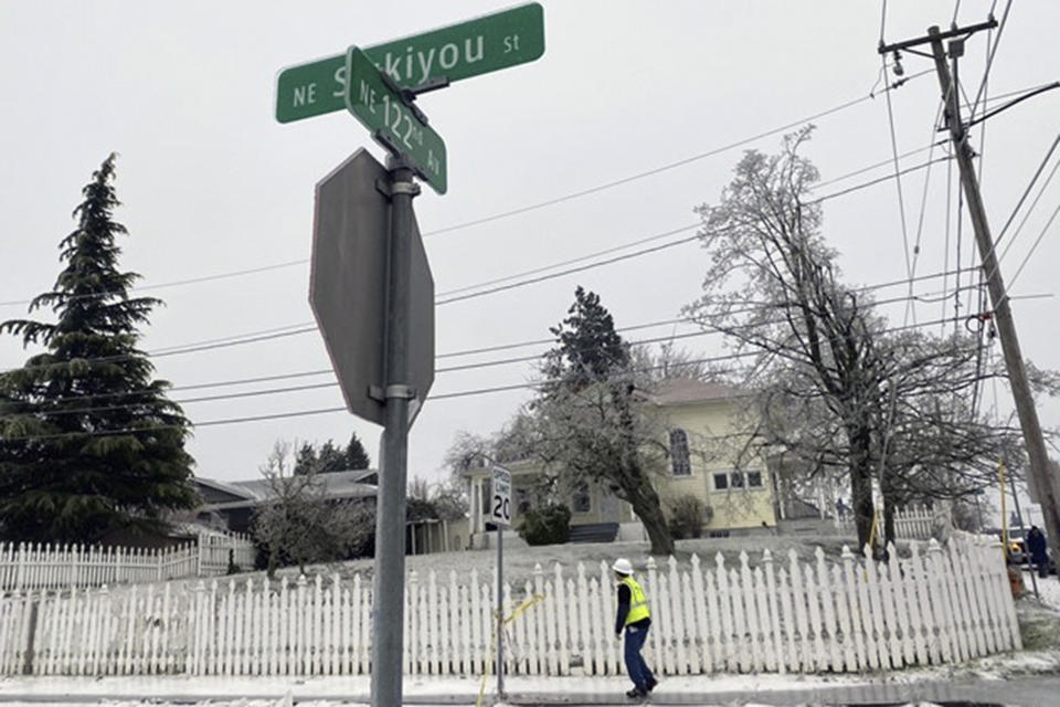 In this image made from video provided by KGW, police tape hangs from a speed limit sign on Wednesday, Jan. 17, 2024, in Portland, Ore., near the scene after a power line fell on a vehicle killing three people and injuring a baby during an ice storm. (Joe Raineri/KGW via AP)