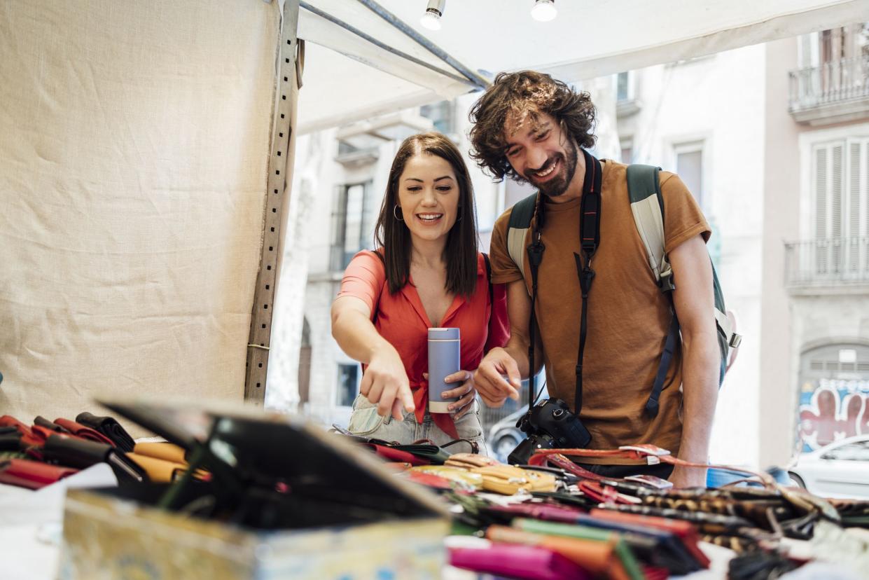 Young couple exploring Barcelona and buying souvenirs.