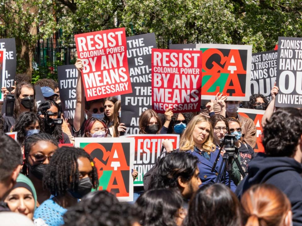 A group of NYU students, faculty and supporters hold signs during a rally in Washington Square Park to protest the arrests. ZUMAPRESS.com