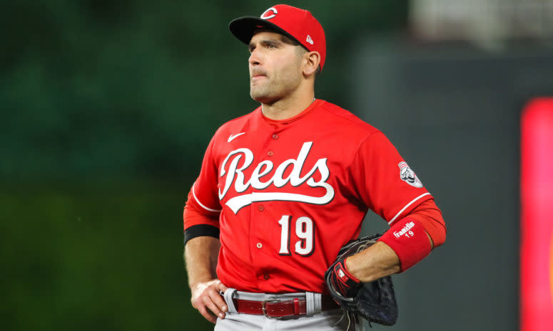 Joey Votto stands in the field with his hands on his hips.