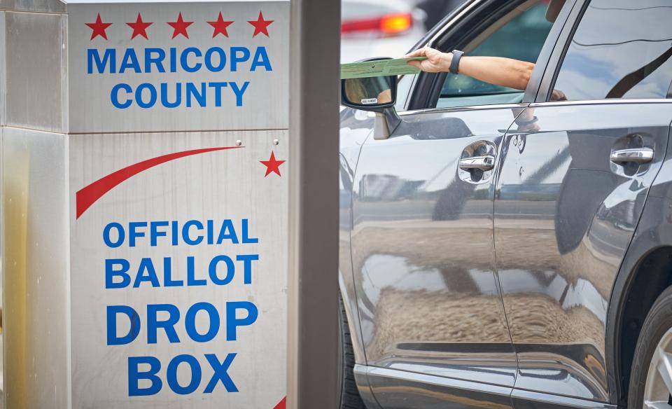 A voter drops off their ballot at the ballot drop box outside the Maricopa County Tabulation and Elections Center in Phoenix for Arizona’s Aug. 2, 2022, primary election.