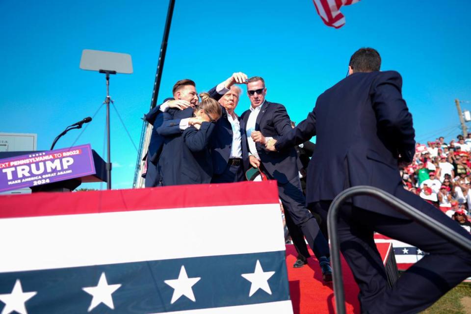 Former President Donald Trump is surrounded by Secret Service agents at a campaign rally in Butler, Pennsylvania, Saturday, July 13, 2024. Trump was escorted off the stage and into his motorcade by Secret Service agents just minutes into his rally in Butler, Pennsylvania, on Saturday after a series of bangs that sounded like gunshots were heard. (Doug Mills/The New York Times)
