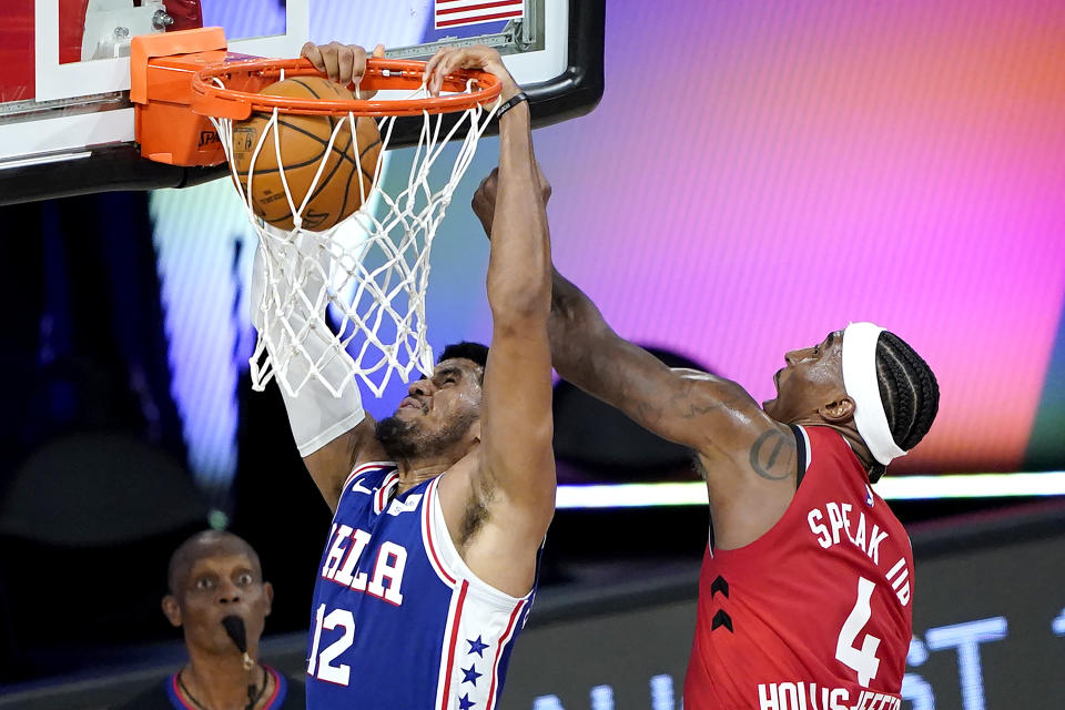 Philadelphia 76ers' Tobias Harris (12) scores a basket against Toronto Raptors' Rondae Hollis-Jefferson (4) during the first half of an NBA basketball game Wednesday, Aug. 12, 2020 in Lake Buena Vista, Fla. (AP Photo/Ashley Landis, Pool)