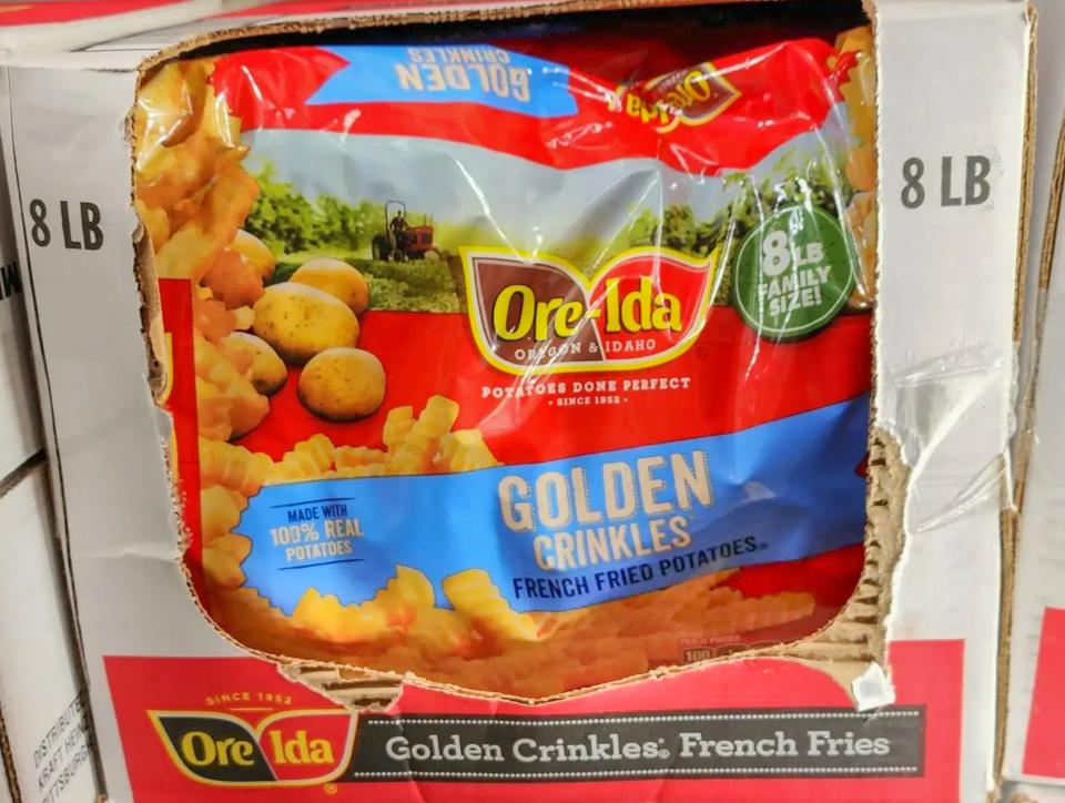 Bright-red package of Ore-Ida golden crinkles french-fried potatoes with blue labels and images of fries and potatoes on bag