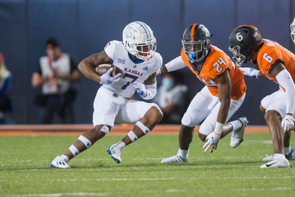 Kansas wide receiver Trevor Wilson (7) runs with the ball as Oklahoma State cornerbacks Jarrick Bernard-Converse (24) and Jabbar Muhammad (6) close in during the second quarter of an Oct. 30, 2021 game at Boone Pickens Stadium in Stillwater, Oklahoma.