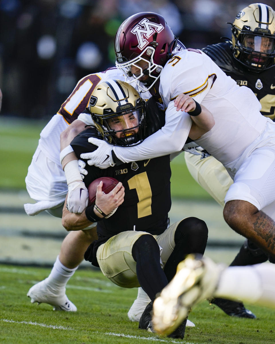 Purdue quarterback Hudson Card (1) is tackled by Minnesota linebacker Devon Williams (9) after a run during the first half of an NCAA college football game in West Lafayette, Ind., Saturday, Nov. 11, 2023. (AP Photo/Michael Conroy)