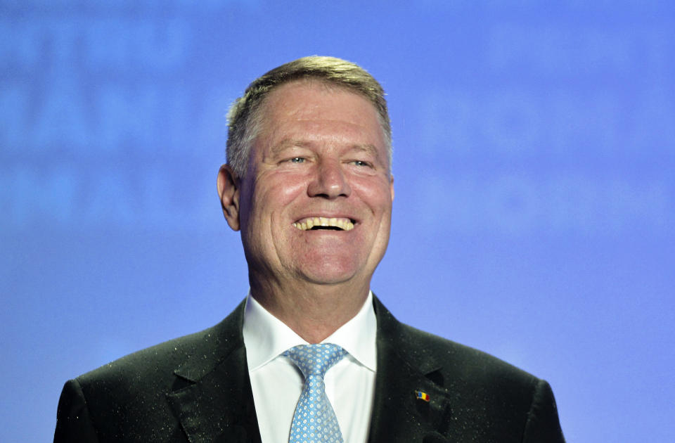 Romanian President Klaus Iohannis smiles upon seeing exit polls results which indicate him as the leader of the presidential race, with up to 40 percent of the votes in Bucharest, Romania, Sunday, Nov. 10, 2019. Romania held a presidential election Sunday after a lackluster campaign that has been overshadowed by the country's political crisis, which saw a minority government installed just a few days ago. (AP Photo/Andreea Alexandru)