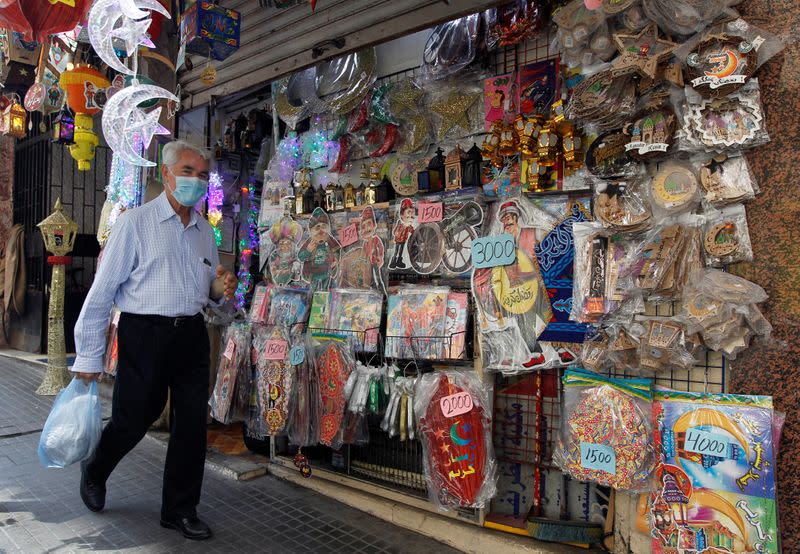 An elderly man wears a face mask as he walks past a shop selling Ramadan items ahead of the Muslim holy month of Ramadan, during a countrywide lockdown over the coronavirus disease (COVID-19) in Beirut