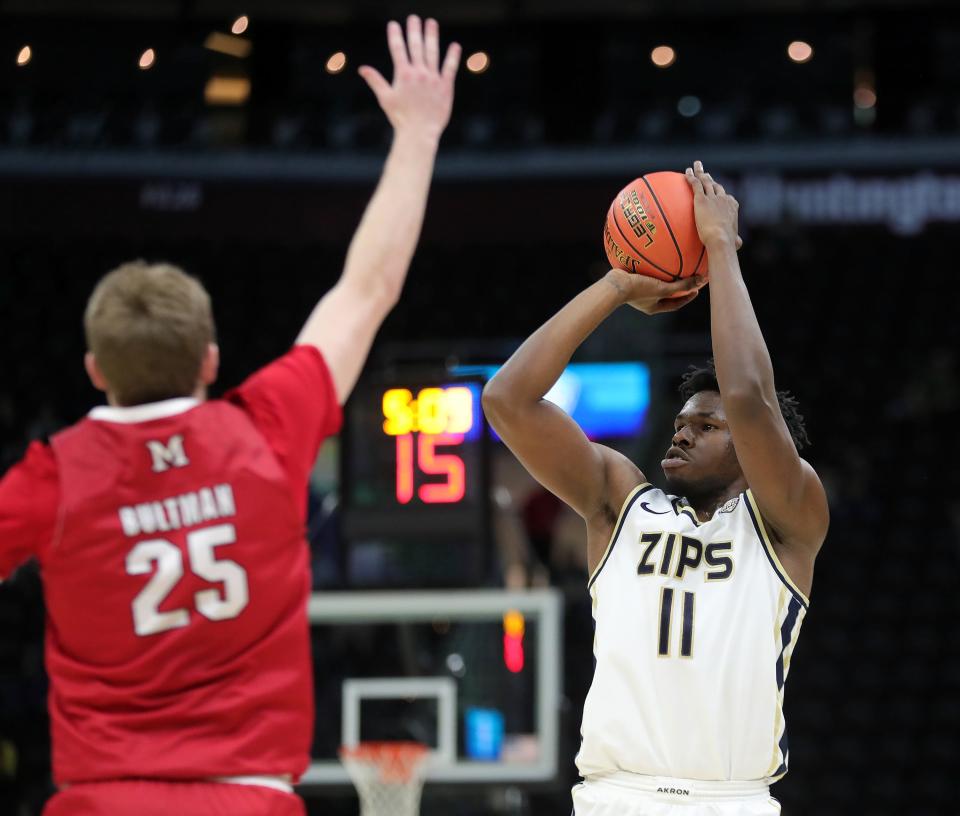 Akron's Sammy Hunter (11) shoots against Miami's Bryce Bultman (25) in the quarterfinals of the Mid-American Conference Tournament on Thursday in Cleveland.