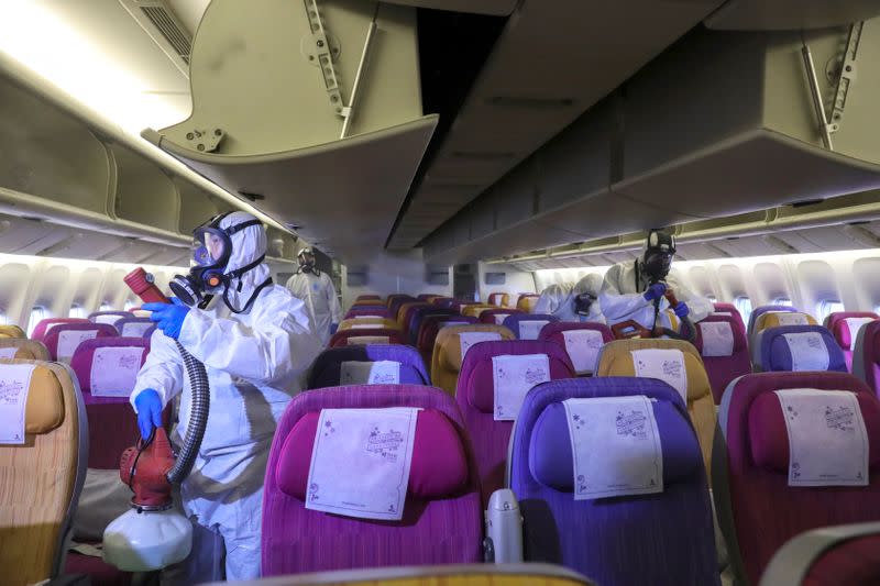 Members of the Thai Airways crew disinfect the cabin of an aircraft of the national carrier during a procedure to prevent the spread of the coronavirus at Bangkok's Suvarnabhumi International Airport